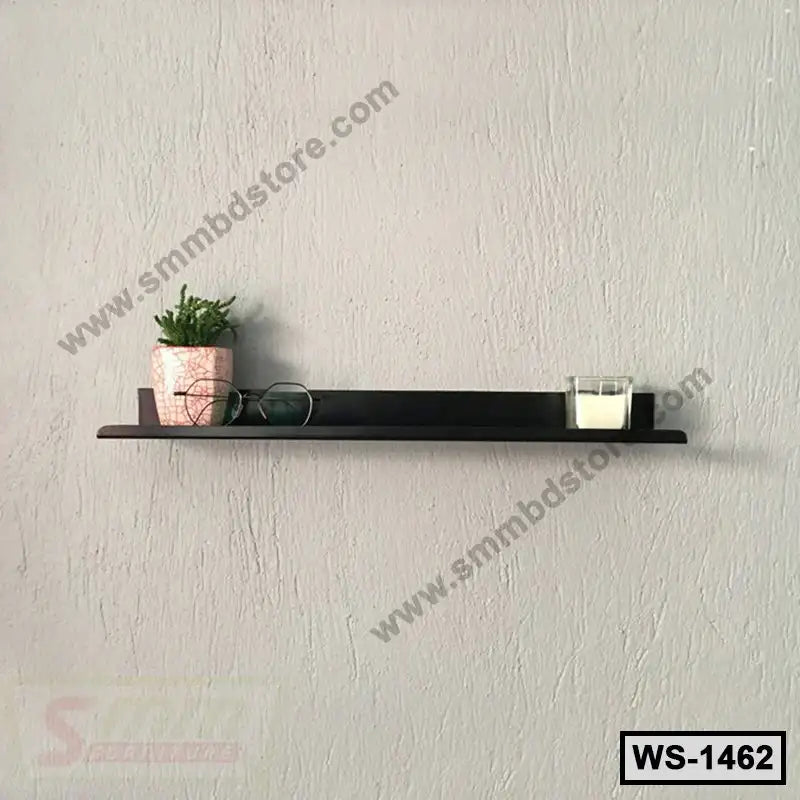 Modern wall shelf with small plant, glasses, and candle on a textured grey wall