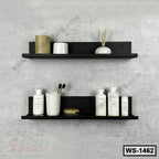 Modern black wall shelves mounted on a light grey wall holding bathroom accessories and decor.