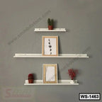 Modern wall shelves set on grey wall displaying framed art, decorative plants, and ornaments
