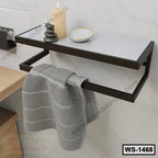 Modern wall-mounted shelf with towel bar, candle, stones, and dish, ideal for bathroom decor.