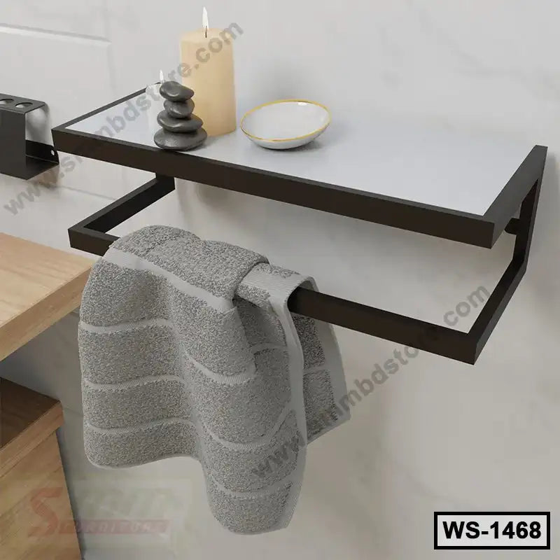 Modern wall-mounted shelf with towel bar, candle, stones, and dish, ideal for bathroom decor.