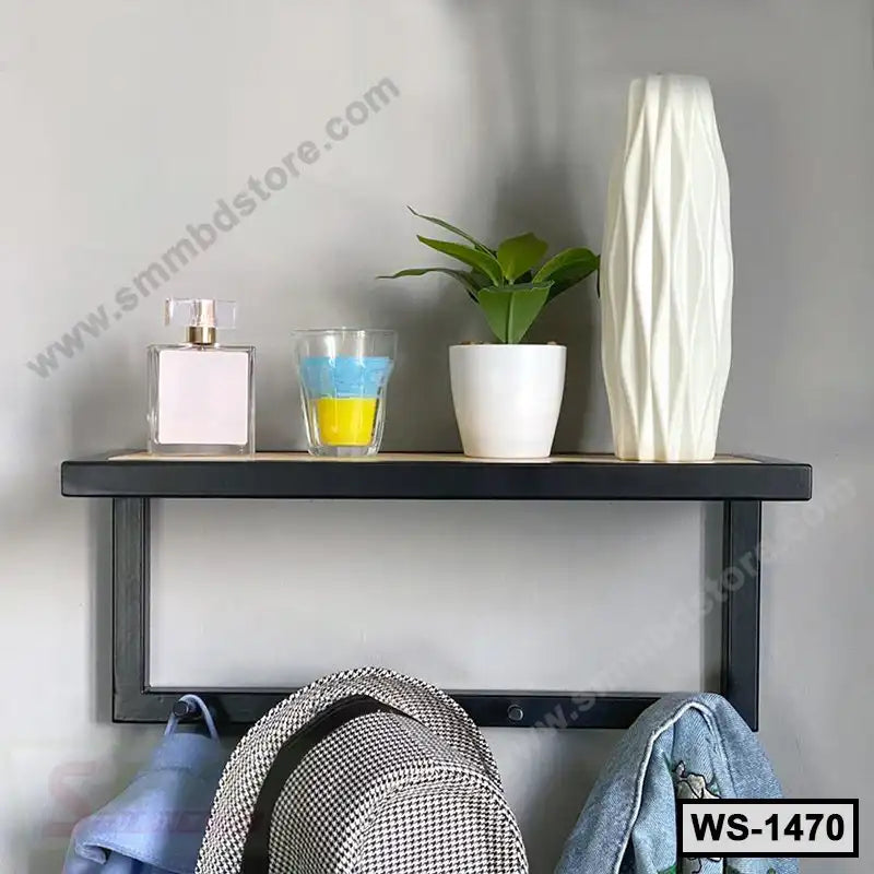 Modern black wall shelf with decorative items, plant, vase, and hooks for hanging essentials