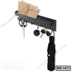 Wall-mounted black metal shelf with hooks, holding scissors, keys, umbrella, and mail organizer.