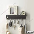 Wall-mounted black storage shelf with hooks holding keys and accessories, clock and photo frame on top.