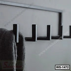 Black metal wall hook rack mounted on a gray wall, holding a hanging coat.