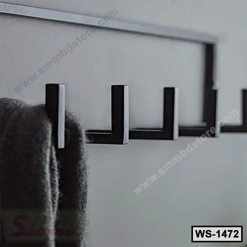 Black metal wall hook rack mounted on a gray wall, holding a hanging coat.
