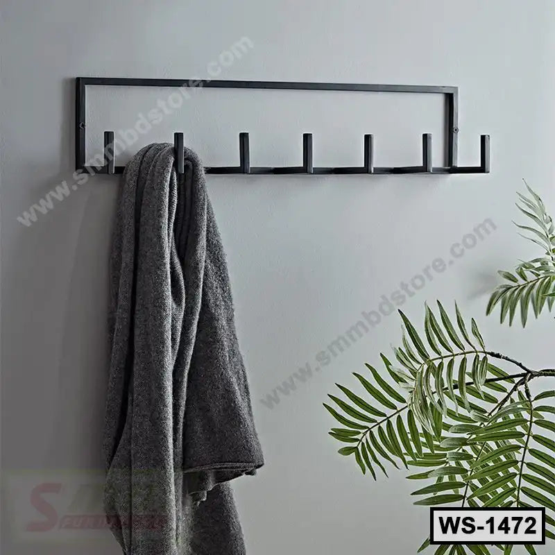 Modern black wall shelf with six hooks, holding a gray towel, indoor plant nearby