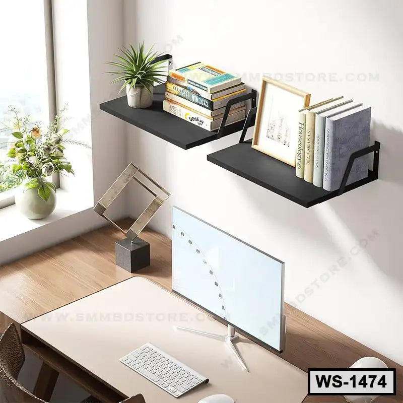 Modern black wall shelves with books and plants above a minimalist computer desk