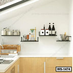Modern black floating wall shelves in a kitchen holding jars, bottles, cups, and utensils.