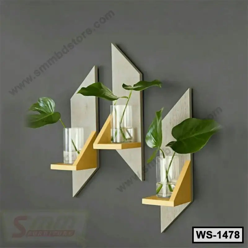 Modern geometric wall shelves with glass vases and green leaves on a gray wall