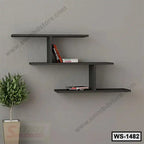 Modern black wall shelf with books, mounted on grey wall above potted plant