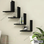 Modern black wall shelf unit with books, decor items, and indoor plant in a living room.