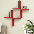 Modern red wall shelf with geometric design, holding books and decor items, mounted in a living room.
