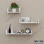 Modern white floating wall shelves with decor, clock, and plant on beige wall