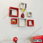 Modern red and white floating wall shelves with books, vase, and decor in a living room.