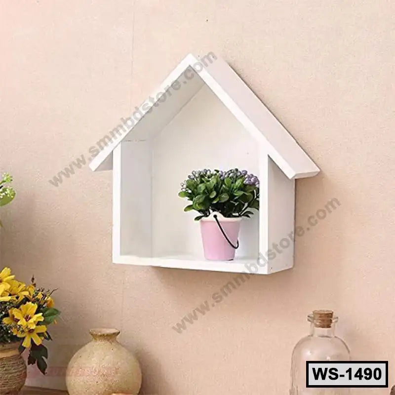 White wall-mounted house-shaped shelf with a small potted plant, modern home decor.