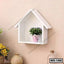 White wall-mounted house-shaped shelf with a small potted plant, modern home decor.
