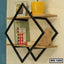 Modern wall shelf with black geometric metal frame, wood shelves, books, yellow planter