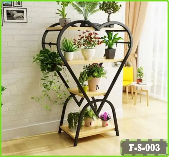 Heart-shaped metal plant stand with wooden shelves displaying potted indoor plants