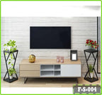 Modern living room with wall-mounted TV, light wood TV console, indoor plants, and decorative items.