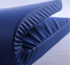Folded blue hospital bed mattress with smooth, waterproof cover on a white background.