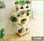 Heart-shaped wooden plant stand with potted indoor plants in bright living room corner