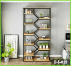 Modern black metal and wood bookshelf with geometric design, decorated with plants, books, and home decor items in a living room setting.