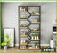 Modern black metal and wood bookshelf with geometric design, decorated with plants, books, and home decor items in a living room setting.